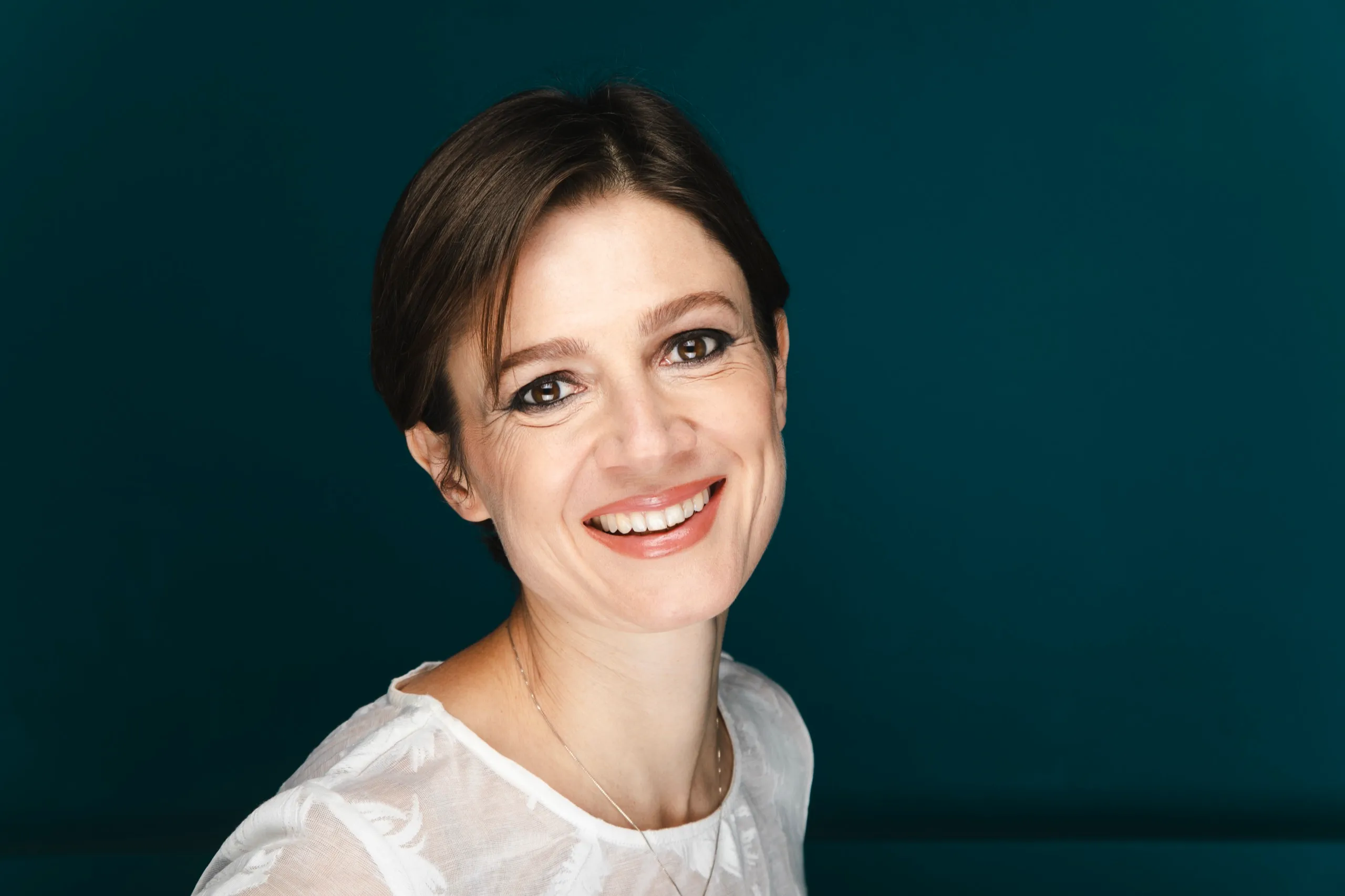 Silvia Bencivelli sorride, su fondo turchese
